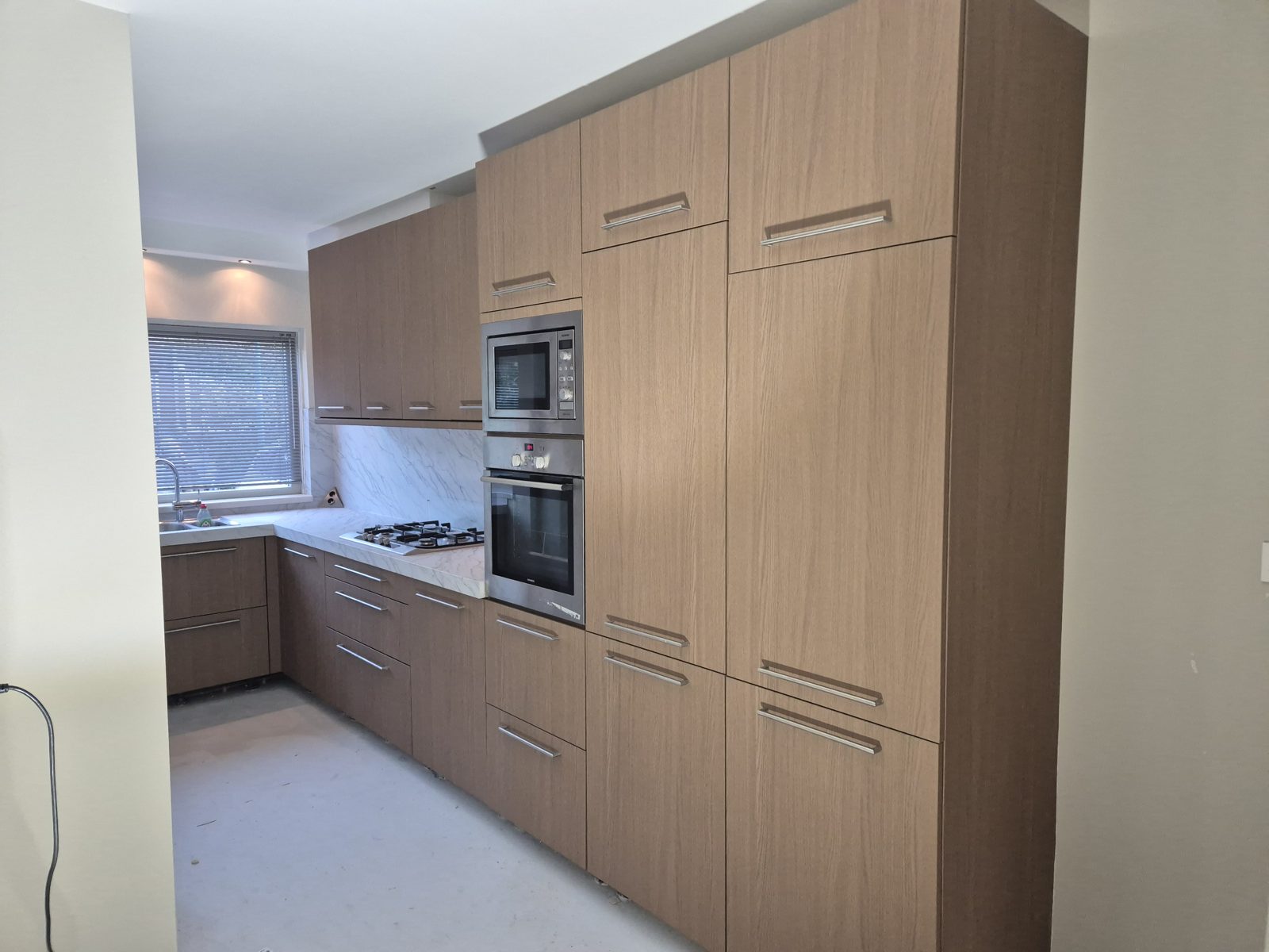 Dezelfde keuken na het wrappen in SOIF Light Walnut Oak met Carrara marmerlook werkblad, Maarssen
